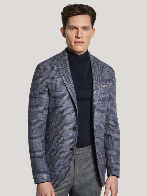 Man wearing blue and brown plaid blazer with notch lapels and single-button closure over dark turtleneck.