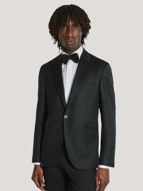 Dark teal textured dinner jacket with notch lapels, worn with white dress shirt and black bow tie.
