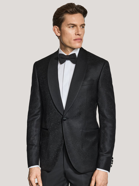 Black paisley dinner jacket with notch lapels, worn with white dress shirt and black bow tie.