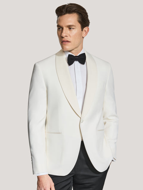 Cream dinner jacket with shawl collar worn with white dress shirt and black bow tie.