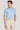 Man wearing light blue crew neck short-sleeve t-shirt with cream trousers.