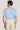 Man wearing light blue crew neck t-shirt with cream pants, shown from back view.