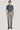 Grey plain front trouser with flat waistband and straight leg, shown styled with navy shirt.