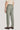Sage green plain front trousers with button closure and flat waistband, worn with cream sweater and brown loafers.