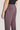 Dusk purple flat-front trouser with button closure and side pocket visible on model wearing black shirt.
