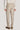 Sand-colored tailored trouser with side fasteners and cuffed hem, shown from back view.
