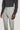 Pearl grey chino pants with button waistband and flat front, worn with dark sweater.