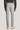 Light grey chino pants with flat front, worn with dark shirt and tan shoes, rear view.