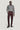 Man wearing berry-colored chino pants with gray quarter-zip sweater and black lace-up boots.