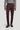 Deep burgundy chino pants with flat front and button closure, styled with gray ribbed sweater and black boots.