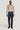 Dark blue wool tailored trousers with side tabs and center crease, worn with beige long-sleeve top.