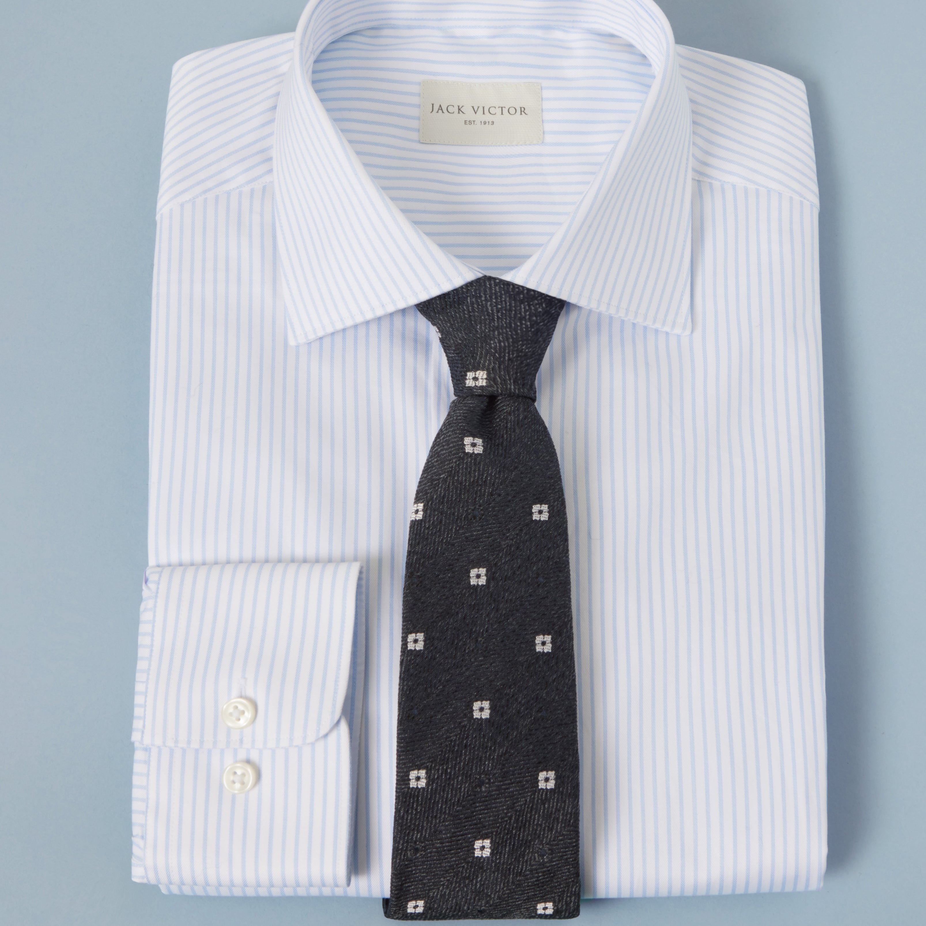 white pinstripe shirt folded with black tie