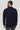Man wearing navy blazer with white shirt collar visible, shown from behind.