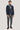 Navy blazer with grey hooded bib layered over charcoal shirt and grey trousers.