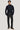 Navy ribbed blazer with detachable gray hooded bib liner, worn over navy sweater and charcoal trousers.
