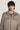 Beige wool shirt jacket with front chest pockets and notched collar, worn over blue ribbed sweater.