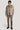 Beige wool shirt jacket with button front, chest pockets, and spread collar worn with matching trousers.