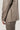 Beige wool jacket with button cuff and matching trousers, shown on model from waist down.