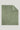 Sage green twill throw blanket with fringe edges on all sides and a small woven label at the corner.