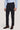 Man wearing light blue button-up shirt and navy flat-front trousers with brown leather dress shoes.