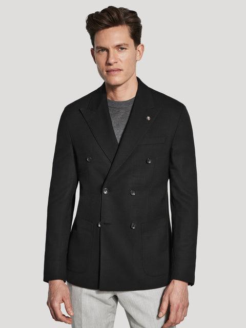 Black double-breasted knit blazer with textured fabric and notch lapels, worn over gray t-shirt.