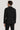 Man wearing black tuxedo suit with white dress shirt, shown from back view.