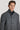 Man wearing charcoal grey wool coat with stand collar and button front closure over navy sweater.