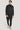 Charcoal double-breasted wool coat with notch lapels, worn over navy turtleneck and dark trousers.