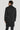 Man wearing charcoal double-breasted coat with notch lapels and button closure, shown from back view.