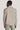 Beige Harrington jacket with collar and long sleeves, shown from back on model wearing sage green pants.