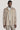 Sand-colored shirt jacket with button front, collar, and chest pockets worn over a white shirt.