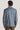 Man wearing blue shirt jacket with long sleeves, shown from back view.