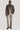 Brown sport jacket with button front and collar, worn with cream trousers and dark shoes.