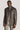 Brown sport jacket with stand collar, button front closure, and chest pocket worn over cream-colored trousers.