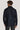 Man wearing navy shirt jacket with long sleeves and collar, shown from back view.