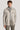 Sand-colored shirt jacket with button front, chest pockets, and wide collar worn over gray turtleneck.