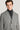 Man wearing black and white herringbone topcoat with notch lapels over a dark turtleneck.