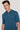Teal polo shirt with short sleeves and white button placket worn by man.