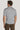 Man wearing light grey short-sleeve polo shirt with ribbed collar and cuffs, shown from back view.