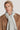 Tan ribbed knit beanie worn by a man with a camel-colored coat and light gray scarf.