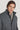 Dark brown ribbed knit beanie worn by man in charcoal wool coat against neutral background.