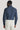 Navy shirt with small white floral print, long sleeves, and collar, worn with cream trousers.