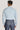 Light blue faded denim shirt with long sleeves and collar, shown on model from back view.