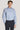 Light blue striped dress shirt with white buttons and pointed collar on model wearing dark trousers.