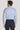 Man wearing light blue micro geoprint dress shirt with spread collar and long sleeves, paired with dark trousers.