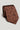 Brown silk tie with geometric pattern featuring ovals, squares, and circular motifs in red, yellow, and navy.