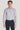 Man wearing lavender micro geoprint dress shirt with white buttons and navy trousers.