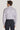 Man wearing lavender micro-geoprint dress shirt with long sleeves and collar, paired with navy trousers, shown from back view