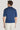 Man wearing navy blue short-sleeve polo shirt with collar, shown from back view.