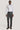 Man wearing white long-sleeve button-up shirt with diamond pattern and dark gray dress pants.